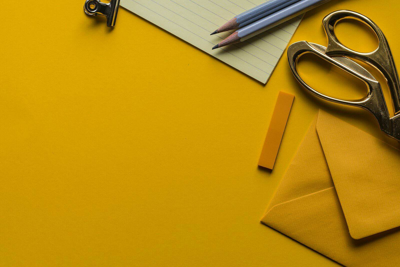 Sobre, tijeras y lápices sobre un escritorio